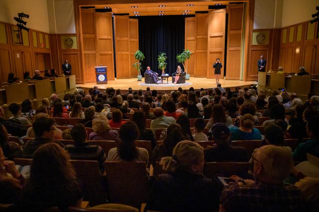 A view of Enlow Recital Hall with most of its seats filled and Clinton and Lesniak on stage. 