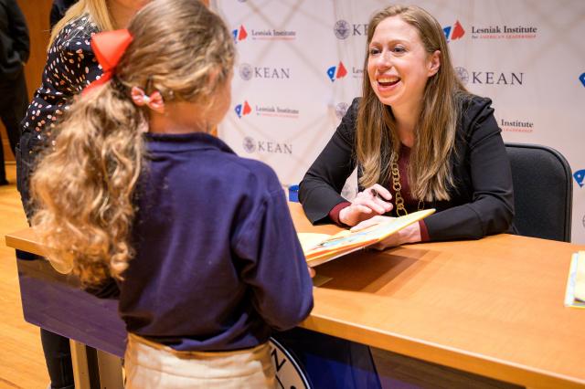 Clinton meets and greets a young girl before signing her book. 