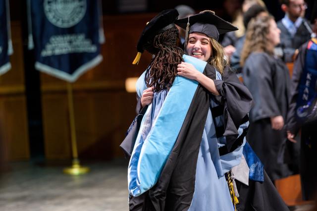 A doctoral candidate is embraced by the Dean of Nathan Weiss Graduate College.