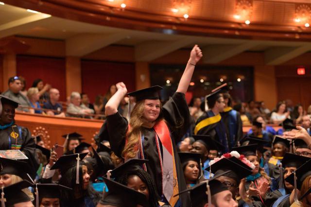 A student in Nathan Weiss Graduate College cheers at Commencement.