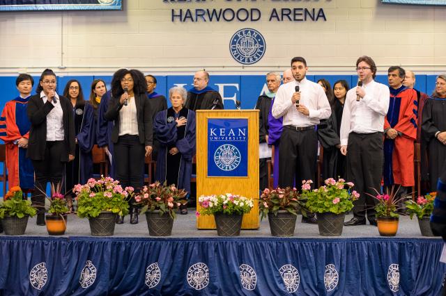 Kean students sign the national anthem on stage before the honors convocation begins