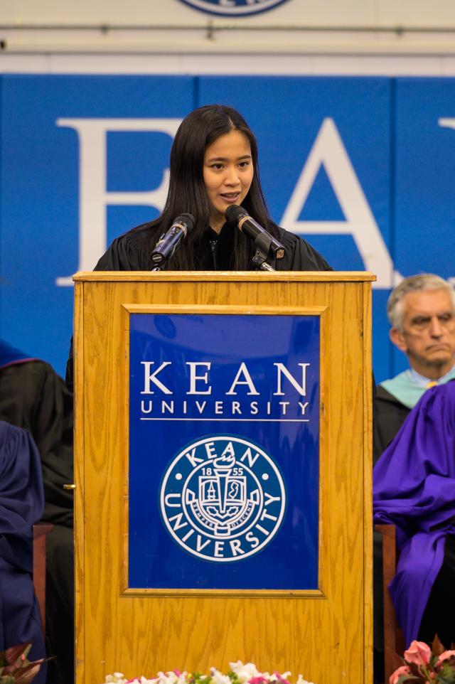 Keynote speaker Dr. Debbie Lin Teodorescu, a physician at Lifespan Healthcare and the founder of SurgiBox stands on stage behind Kean podium