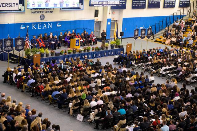 A photo of the entire room shows honors graduates and the stage of Kean employees ready to award graduates with their honors degrees
