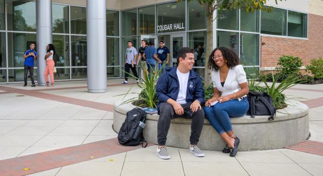 Kean students lounge in front of Cougar Hall