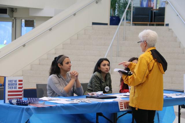 Tabelers speaking with woman during voter registration tabeling