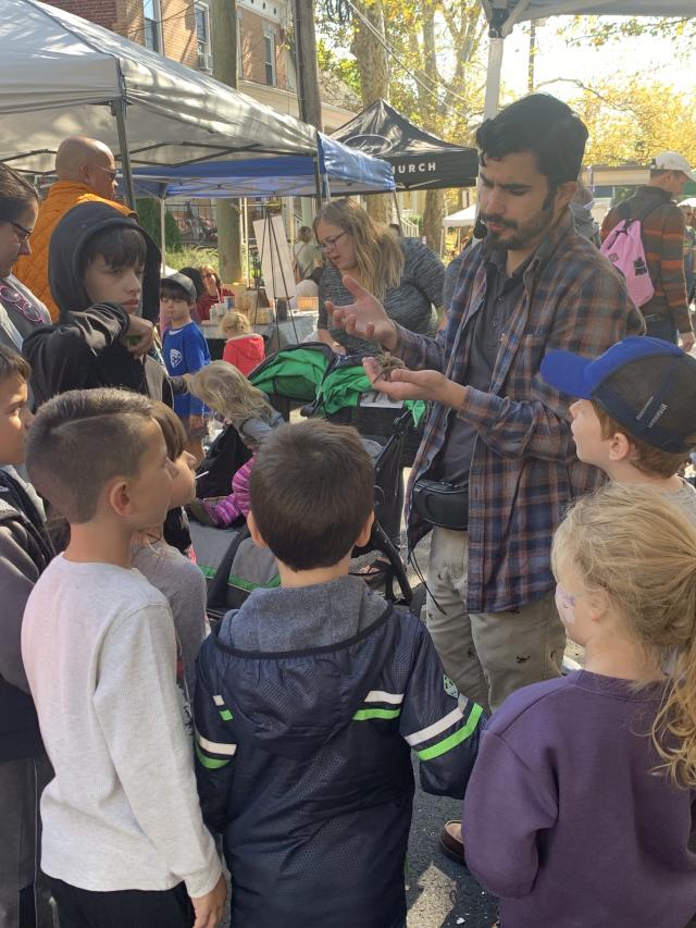 Kean Ocean biology student shows a tarantula to a group of children.