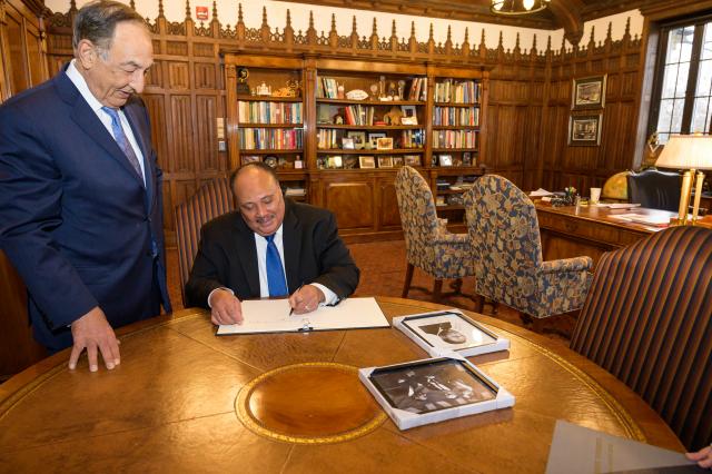 MLK3 signs the Kean guestbook as President Farahi looks on