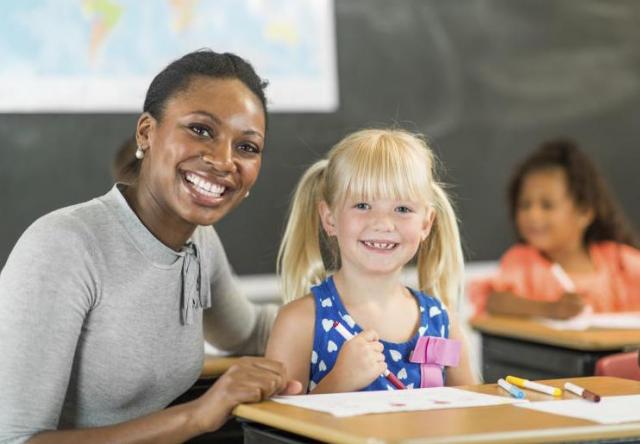Teacher helps elementary student with course work