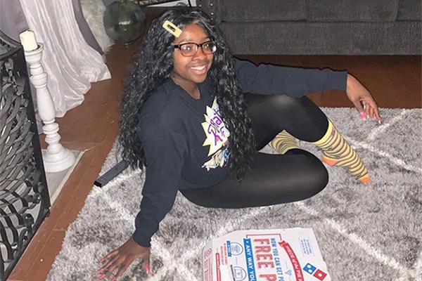 Zaniyah Nichol of Orange poses with her free pizza as part of Kean's Dinner with the Dean event.