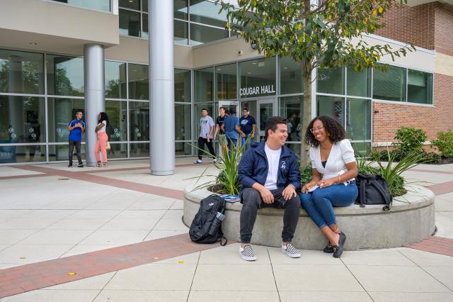 Kean students laugh outside of Cougar Hall