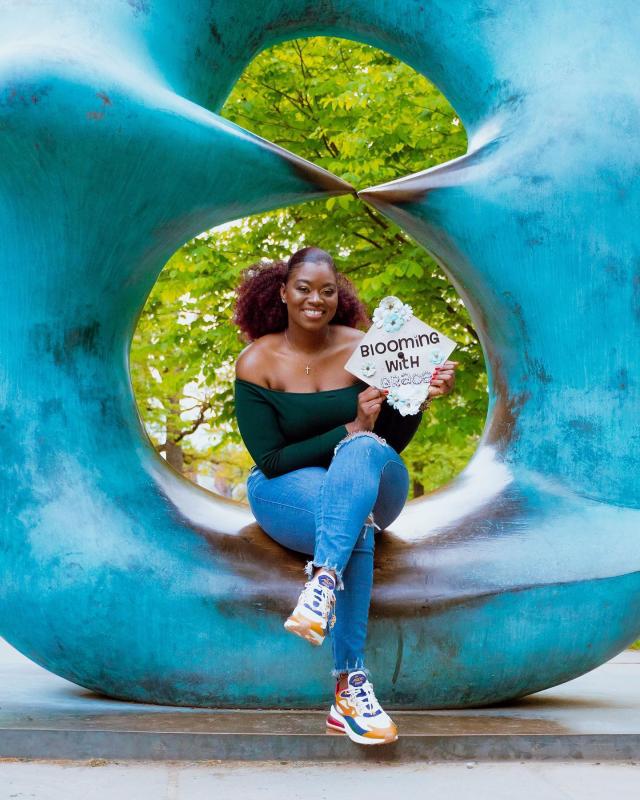 kean grad 2020 sits on sculpture