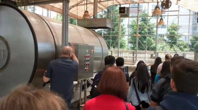 Photo of Kean faculty member showing the large composter used at Kean