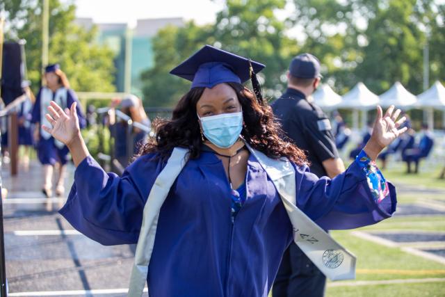 Excited grad extends her hands to wave at the crowd