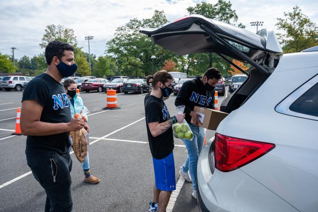 Students unloading food from a car to assist with the emergency food distribution on campus.