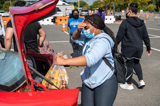 Student carrying food from car to assist in food distribution on campus.