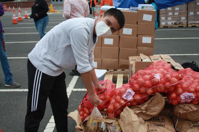 Student carrying food to assist with emergency food distribution on campus.