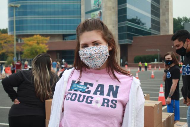 Student posing for a photo at the emergency food distribution on campus.