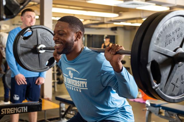 Student lifts weights in the gym
