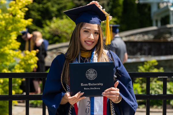 Grad poses with her diploma after Ceremony #5