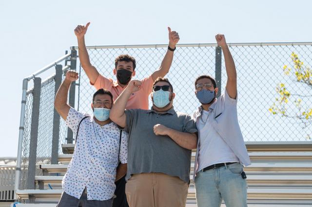 Four supportive fans in the stands at Commencement