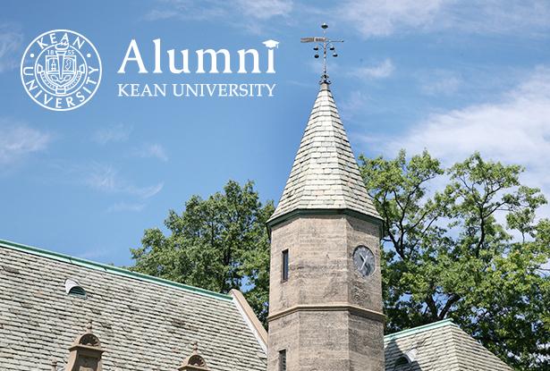 The roof of Kean Hall with the logo for Kean the Alumni Engagement office against a blue sky.