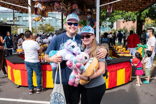 A father and his daughter posing for a photo with their prizes at Homecoming 2021.