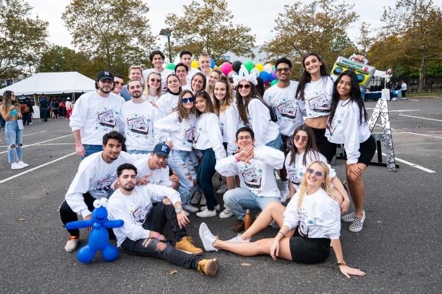 Group of fraternity and sorority sisters and brothers posing for a photo at Homecoming.