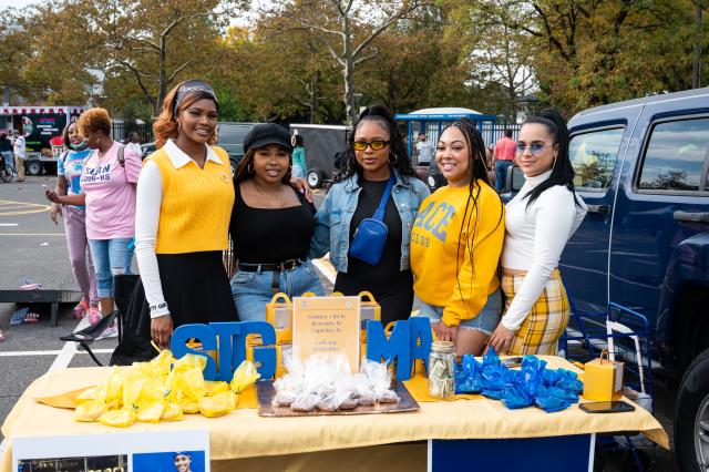 A group of sorority sisters posing for a photo at their table setup at Homecoming 2021.