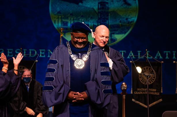 Kean President Repollet smiles as Kean Trustee McDermott places the Kean medal around his neck.