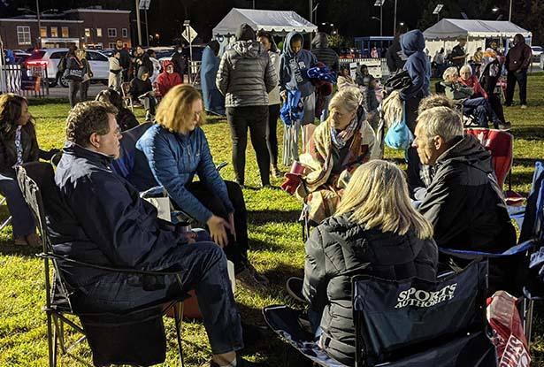 A group of people conversating amongst themselves at the Jazz Roots Festival.