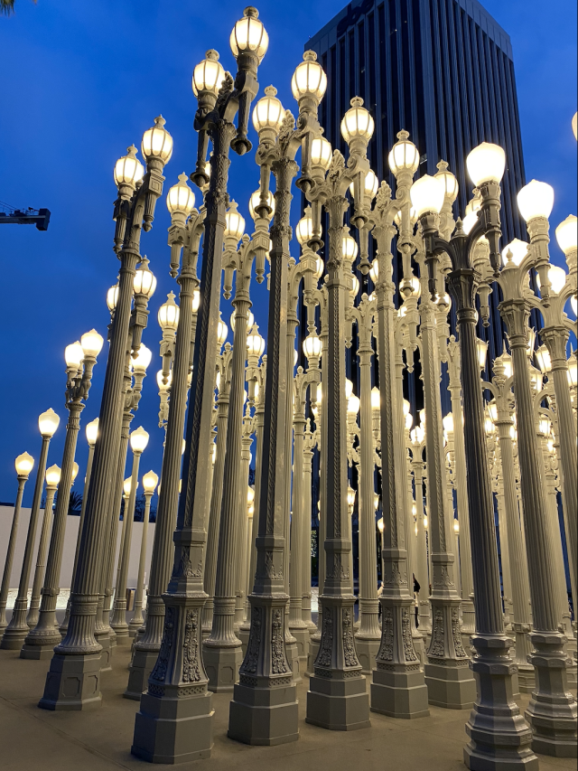 An exhibit at a museum showing gigantically tall, light gray lamp posts.