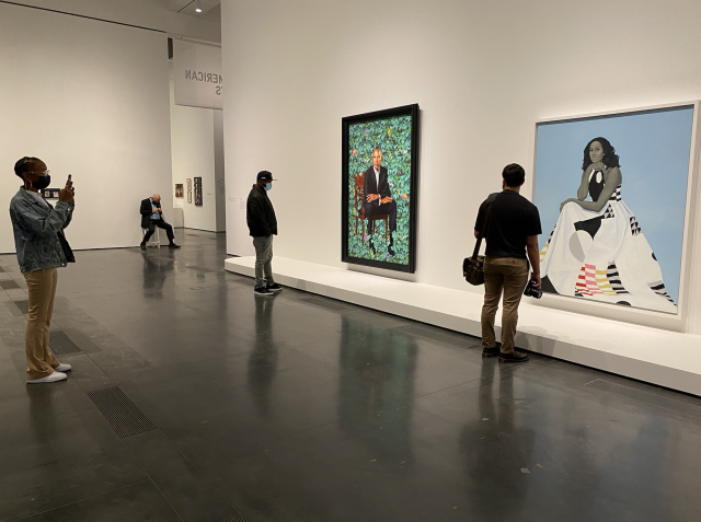 Knowledge Bennett and his two students look at the portraits of Barack and Michelle Obama in a museum.