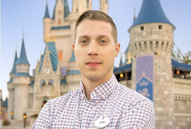 John Weigele standing with his arms folded in front of the Magic Kingdom at Disney World.