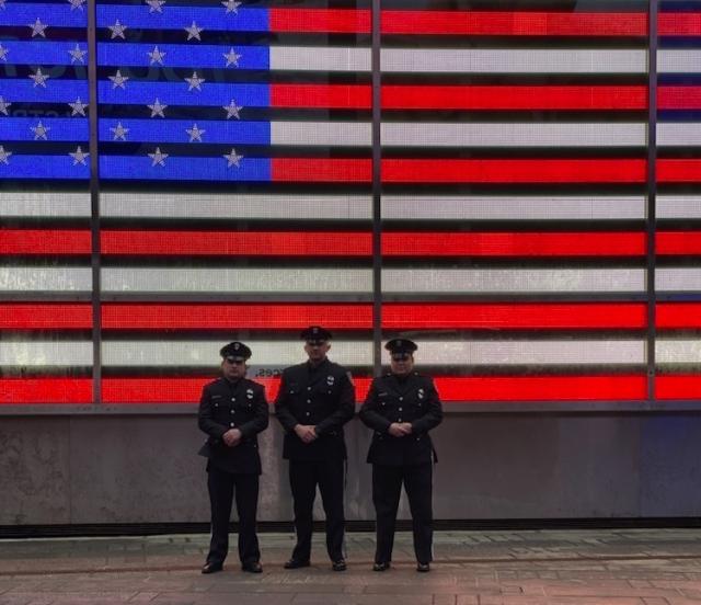 Officers pose in front of American flag banner