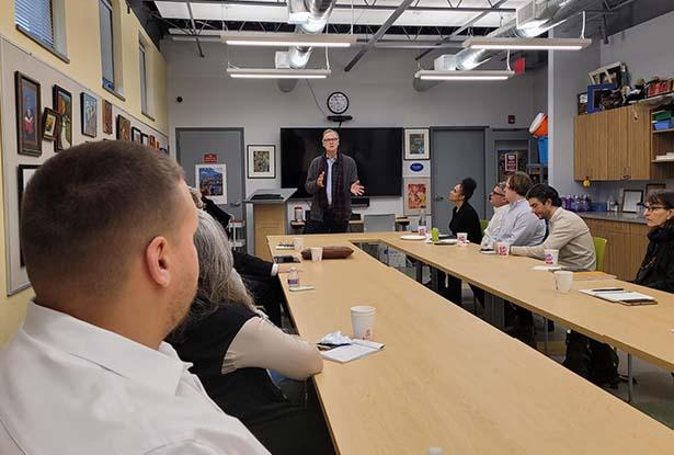 Michael Graves College Dean David Mohney stands at the head of a long table, gesturing.