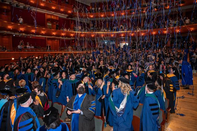 Confetti streams down on Kean graduates as Graduate Commencement concludes.