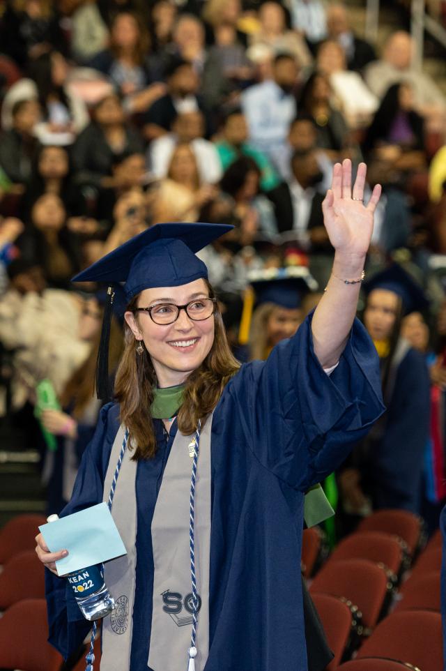 A female student waves.