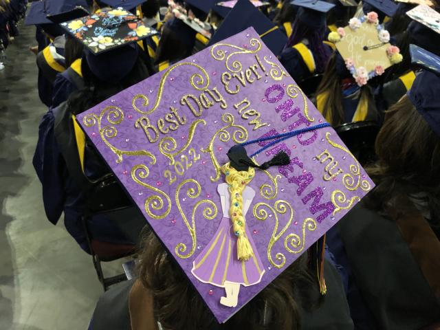 A decorated graduation cap reads, "Best day ever. Onto the dream."