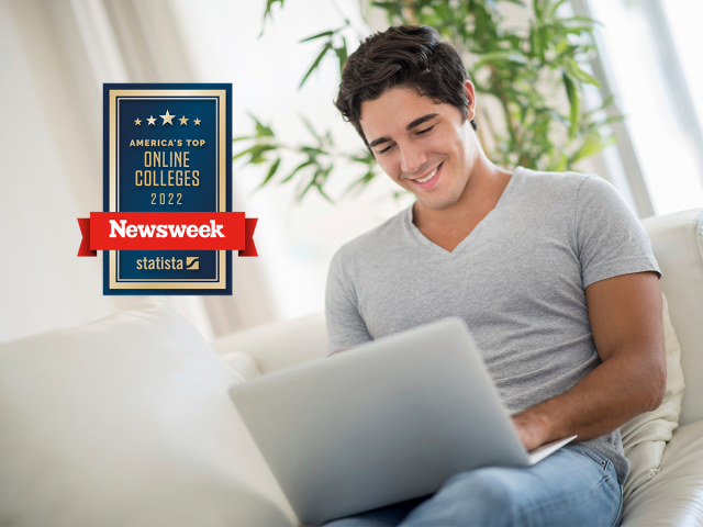 Young man studies on his laptop. Newsweek best online badge in the foreground.