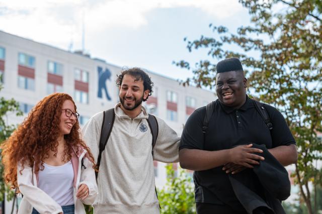 Kean Students laughing near a residence hall building