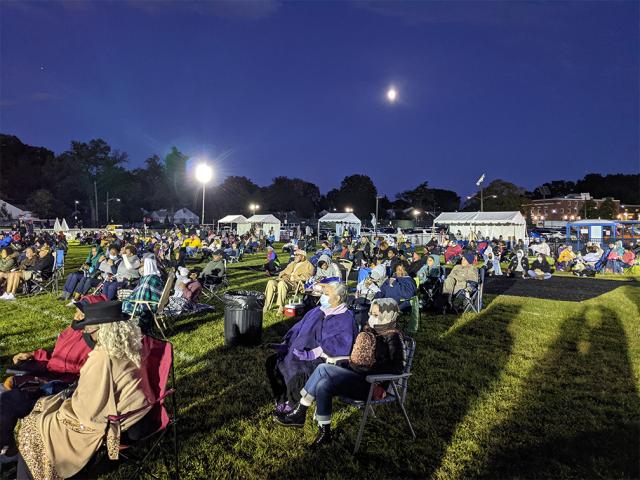 Night view of a lawn and crowd at a festival