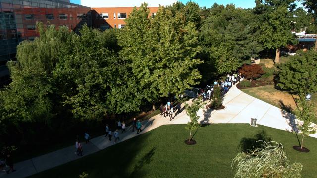An overhead shot of Kean University's campus with a diverse group of people walking under trees.