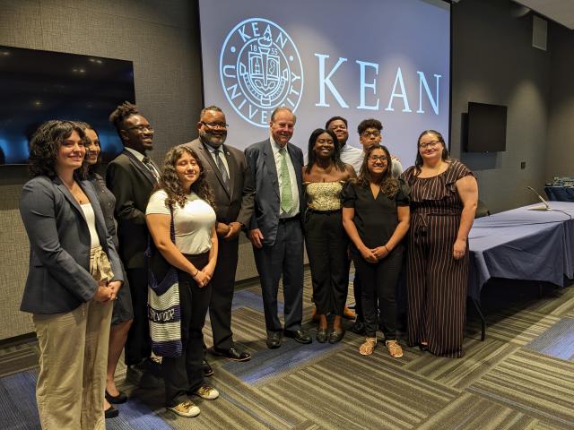 Kean President Lamont Repollet and former NJ Governor Tom Kean pose with Kean students.