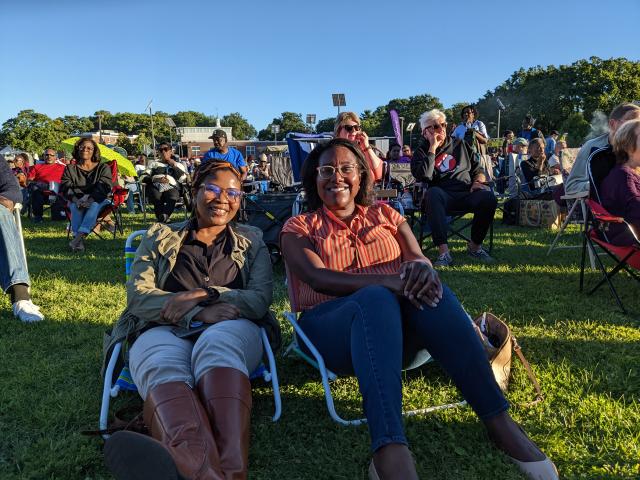 Two young woman sit on lawn chairs at the Jazz and Roots Music Festival.