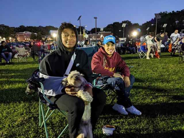 Two young men and their dog at the Jazz and Roots Music Festival.