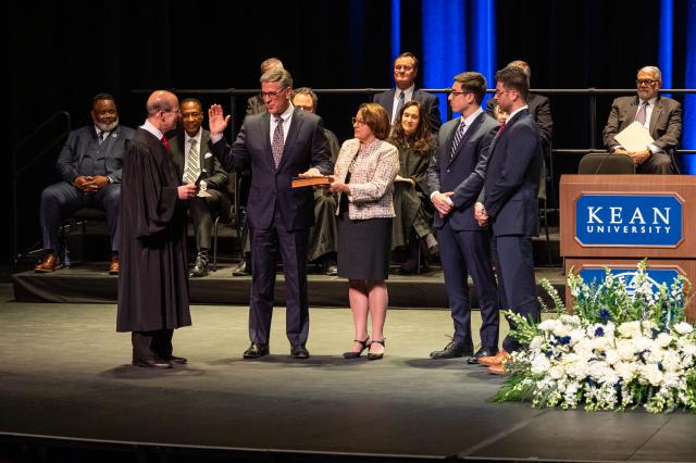 Justice Fasciale takes the oath of office on Wilkins Theatre's stage, surrounded by his wife and sons.