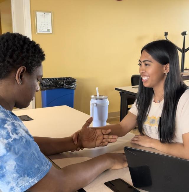 Occupational therapy students practicing manual muscle testing in the graduate lounge