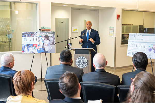 Senator Booker gestures while speaking at a podium