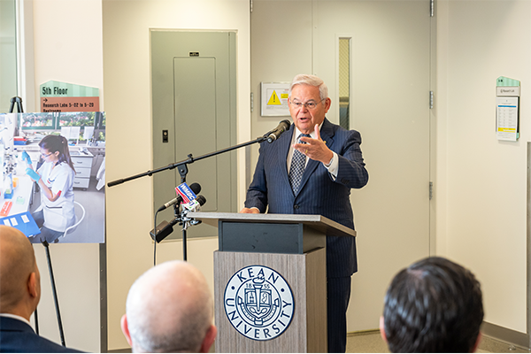 Senator Menendez gestures while speaking at a podium