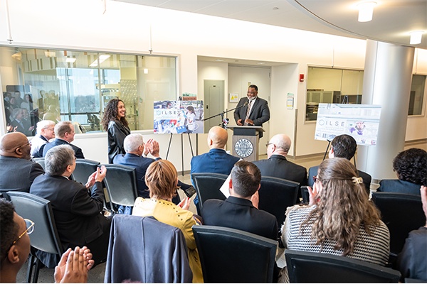 Kean President Repollet at a podium acknowledges a student in the audience